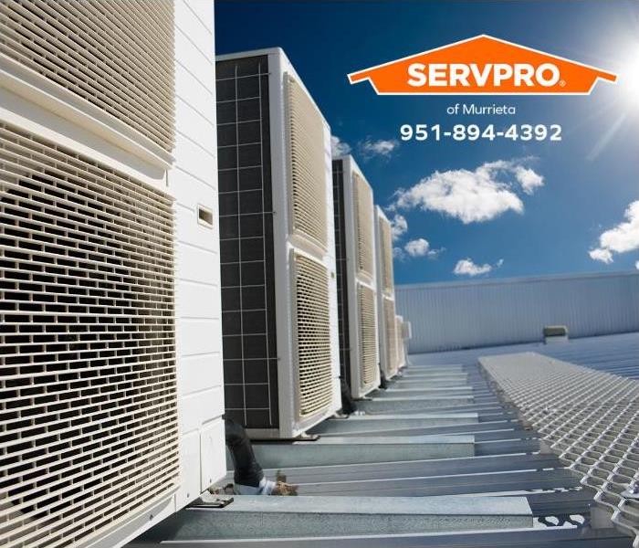 Commercial air conditioning units sit on top of a building.