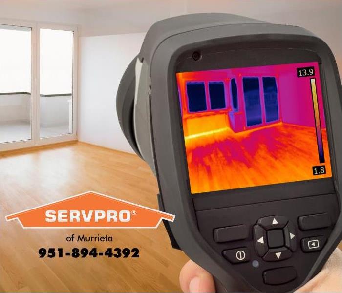 A person is using an infrared camera to detect hidden water damage.