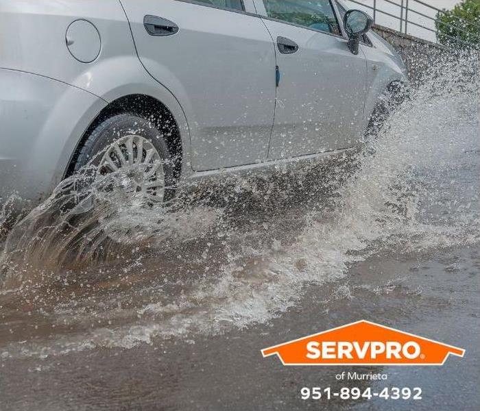 A car drives through dangerous flood waters.