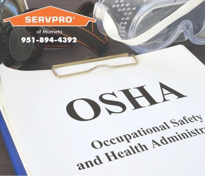 The letters OSHA written on a paper on a clipboard.